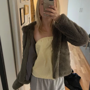 Grå/grön pälsjacka - Mango - Jättemysig grågrön pälsjacka från Mango i storlek M. Jackan är fluffig och långärmad med luva! På insidan vid ryggraden finns slitage men det syns ju inte utifrån och jag tror absolut inte att det kommer att påverka dess upplevelse alls annars💕☺️