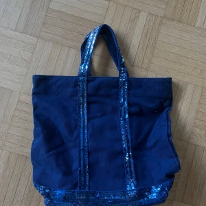 Blå shoppingväska Vanessa Bruno - Snygg blå shoppingväska från Vanessa Bruno med glittriga paljettdetaljer på handtag och nederkant. 