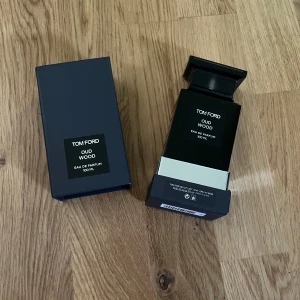 Tom Ford Oud Wood Eau de Parfum 100ml - Exklusiv parfym från Tom Ford, Oud Wood Eau de Parfum i 100 ml flaska. Flaskan är svart med spegelblank silverdetalj på locket och stilren design. Kommer i elegant mörkgrå kartong. En lyxig och populär doft med träiga och varma toner. Det är typ 99 98 ml kvar