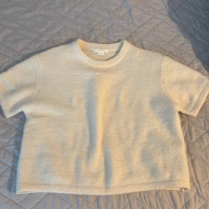 Beige stickad tröja Gina Tricot - Supermjuk och enkel beige stickad tröja från Gina Tricot. Tröjan har korta ärmar, rund halsringning och en rak, lite boxig passform. Perfekt för lager-på-lager och chill dagar. Stilren och lätt att matcha med allt.