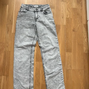 Gråa raka jeans från Lindex Stella 170 - Snygga straight grå jeans från Lindex Stella med raka ben och mid waist. Jeansen har klassisk femficksdesign, justerbar midja med knappresår och cool tvättad look. Perfekta för dig som gillar en avslappnad och trendig stil. Köptes för 400 på Lindex. 