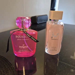 Bourbon Insignia & Hayati Florence parfym - Två parfymer: Bourbon pour femme från Insignia i en glansig, rosa flaska med kristalliknande kork och svart band, samt Hayati Florence från Lattafa i en stilren, transparent flaska med ljusrosa innehåll och beige kork. Perfekt för dig som gillar snygga flaskor och unika dofter. 150 kr för båda parfymerna 