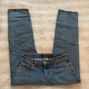Blå raka jeans från Weekday - Säljer ett par klassiska blå jeans från Weekday i modellen Arrow. Jeansen har rak passform, fem fickor och låg midja. Snygg tvättad look i storlek 25/30