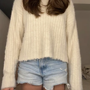 Ljusblå jeansshorts med fransig kant - Snygga ljusblå jeansshorts med rå, fransig kant och slitna detaljer. Klassisk femficksmodell med normal passform och midja. Perfekta för varma dagar och en chill look.