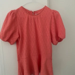 Topp från Lindex - Helt ny, oanvänd sommartopp från Lindex. Sitter väldigt fint med en volang nertill. Inköpt för 450kr