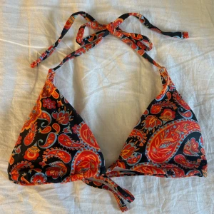 Mönstrad bikiniöverdel  - Orange/röd mönstrad bikiniöverdel i trekantsmodell. Knytband i nacken och ryggen. Storlek xs. Skulle säga att kupan är A eller B🧡❤️