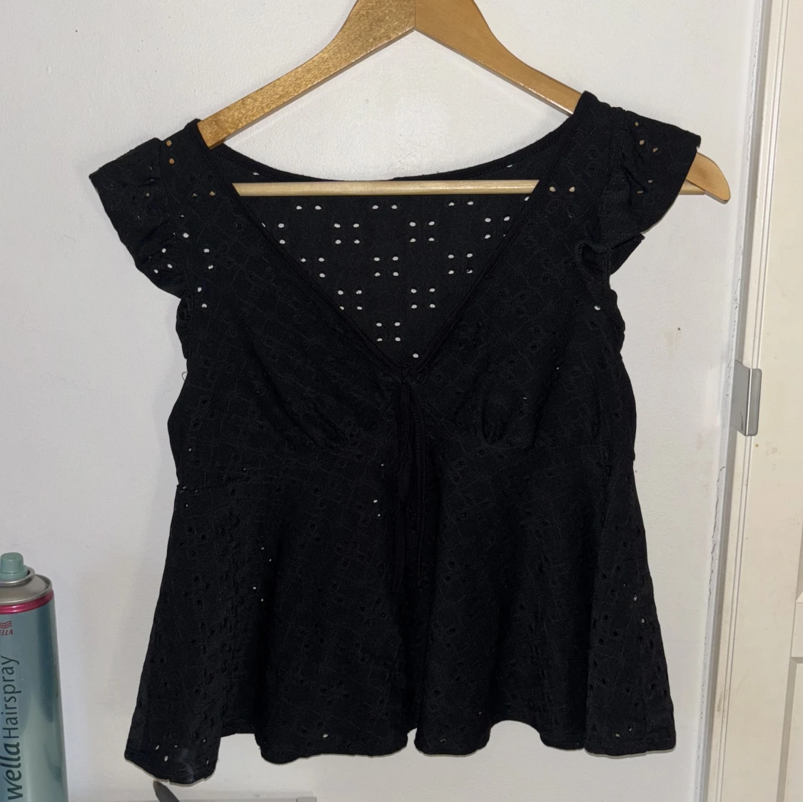 Svart blus med knyt och broderade hål