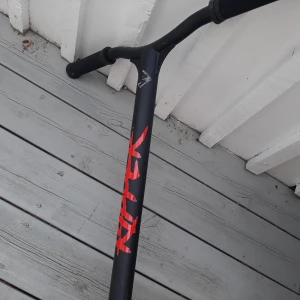 Kickbike - Bilderna visar en röd och svart kickbike/sparkcykel av märket Street Surfing, modell Ripper. Den har robust konstruktion och cool design, perfekt för tricks och street riding. Passar dig som vill sticka ut och ha kul på stan eller i skateparken.