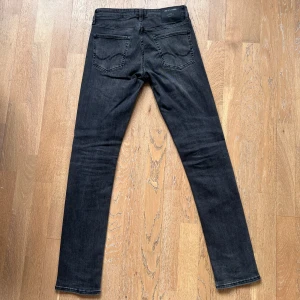 Jack & Jones Jeans - Riktigt feta svarta jeans med en slim passform ifrån Jack & Jones. Knappast använda. De har en klassisk femficksdesign och dragkedja. Perfekta för en stilren look. Tveka inte om att skriva om du har några frågor. MODELL SLIM GLENN, Modell: 185cm 62kg