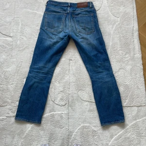 Blå jeans från Tiger of sweden - Säljer ett par klassiska blå jeans från Tiger of sweden. De har en straight passform och är tillverkade i slitstarkt denim. Byxorna har fem fickor och en knappgylf. Perfekta för en avslappnad stil.