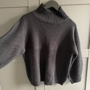 Svart stickad polotröja - Svart stickad polotröja från Monki i storlek M.