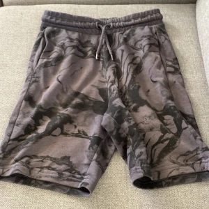 Grå mönstrade shorts med snörning - Snygga grå shorts med ett unikt mönster och bekväm passform. De har en elastisk midja med snörning för justerbarhet. Perfekta för en avslappnad stil. Ord pris när jag köpte dom kosta 210kr 