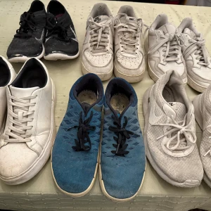 Samling av sneakers - Säljer en samling sneakers i olika stilar och färger. Inkluderar vita sneakers med snörning, blå sneakers med svart snörning och flera par vita Nike-sneakers. Perfekt för den som vill ha variation i sin skogarderob. Alla skor för ett totalpris av 500kr. Storlek 43-45.
