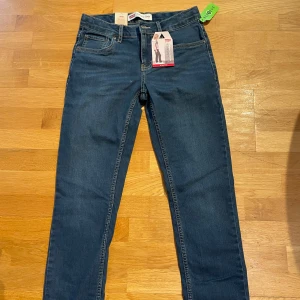 Levi's 512 Slim Taper Jeans - Snygga Levi's 512 Slim Taper jeans i en klassisk blå färg. Dessa jeans har en slim passform med avsmalnande ben och är tillverkade i stretchigt denim för extra komfort. Perfekta för en stilren look.