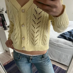 Gul stickad kofta med pärlknappar - Säljer en söt gul stickad kofta med v-ringning och söta pärlknappar🌸Koftan har ett fint mönster och långa ärmar. Hör av er vid frågor!💗