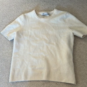 Beige kortärmad tröja från Zara - Säljer en stilren beige tröja från Zara. Den är kortärmad med ribbade kanter vid ärmslut och nederkant. Perfekt för en avslappnad look. Passar bra till både jeans och kjol. 🧡