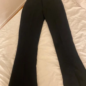 Svarta lågmidjade bootcut kostymbyxor från Bik Bok - Snygga svarta bootcut kostymbyxor från Bik Bok i storlek XS. Vet tyvärr inte vilket modell de är, 76cm innebenslängd. För korta för mig som är 175 ( med långa ben) 
