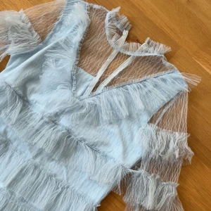 Ljusblå klänning med volanger - Säljer denna super söta klänning med volanger. Väldigt lik By malina klänningarna. Nytt skick! Pris går även att diskutera💕