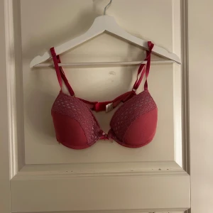 Rosa spets-bh med rosett - Snygg rosa bh med spetsdetaljer och en söt rosett framtill. Justerbara axelband för perfekt passform. Perfekt för att känna sig extra fin under kläderna.