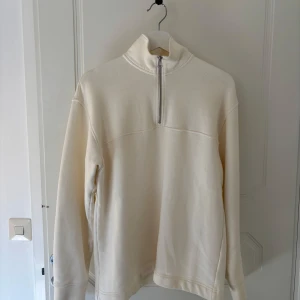 Vit tröja med dragkedja - Säljer en vit tröja med dragkedja och hög krage. Tröjan har långa ärmar. 