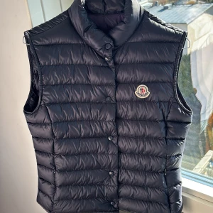 Navy blue dunväst från Moncler - Snygg navy blue dunväst från Moncler med knappar. Passar perfekt till en solig vårdag. Pris kan diskuteras vid snabb affär.