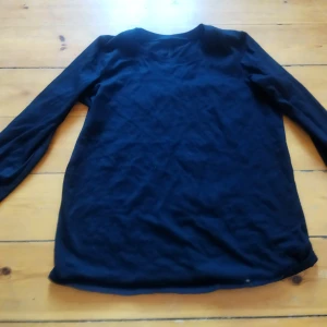 Svart långärmad tröja - Säljer en enkel och stilren svart långärmad tröja. Perfekt för lager-på-lager eller som den är. Passar till många olika outfits och tillfällen.