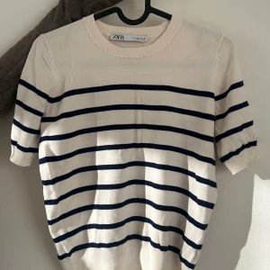 Randig tröja från Zara - Säljer en randig tröja från Zara i beige och svart. Har en jättefin passform och den är väll använd men i gott skick, bortsätt från kragen (se bild 3) men som inte påverkar utseendet overall! Har varit väldigt älskad! Pris kan diskuteras❤️
