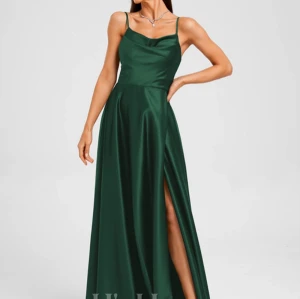 Grön långklänning med slits/ balklänning - Grön långklänning med slits, använd som klänning till studentbal. Fint skick, endast använd en kväll.