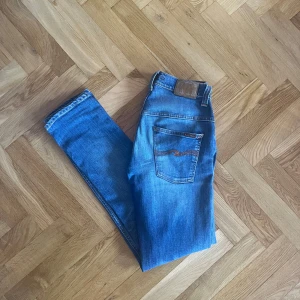 Blå Nudie Jeans - Tjenare, Säljer ett par klassiska blå jeans från Nudie Jeans i L34 W30, (sitter som L32) nypris cirka 1400kr mitt pris 549kr. Jeansen är i exceptionellt skick, 9/10 inte mycket slitage alls. Vid frågor och funderingar så är det bara att skicka ett DM.🤩
