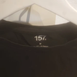 Svart croppad topp från 157 - Snygg svart croppad topp från 157. Perfekt för en stilren look med korta ärmar och en bekväm passform. Tillverkad i bomull med en touch av elastan för extra stretch.