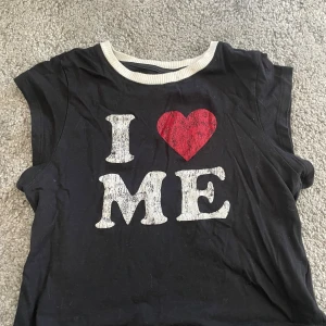 T-shirt i ❤️me - Säljer en svart t-shirt med ett tryck 'I ❤️ ME' i vitt och rött framtill. Använd ett flertal gånger, se defekter på bild 3&4