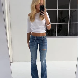 Low waist jeans  - Ginatricot ny lanserade Young 14+ years flare jeans med slitna detaljer framtill som är helt slutsålda i XS. Jeansen är ljusblåa och har låg midja. De har utsvängda ben, låg stretch, dragkedjegylf, dubbla knappar i sidan och fickor fram och bak. Priset går att diskuteras❣️❣️