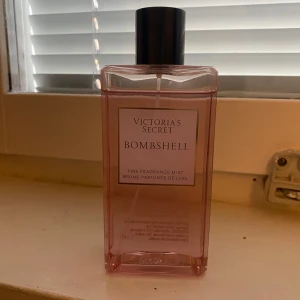 Victoria's Secret Bombshell Fragrance Mist - Säljer en Victoria's Secret Bombshell Fine Fragrance Mist. Flaskan är rosa och har en elegant design med svart lock. Perfekt för en fräsch och blommig doft som varar hela dagen.