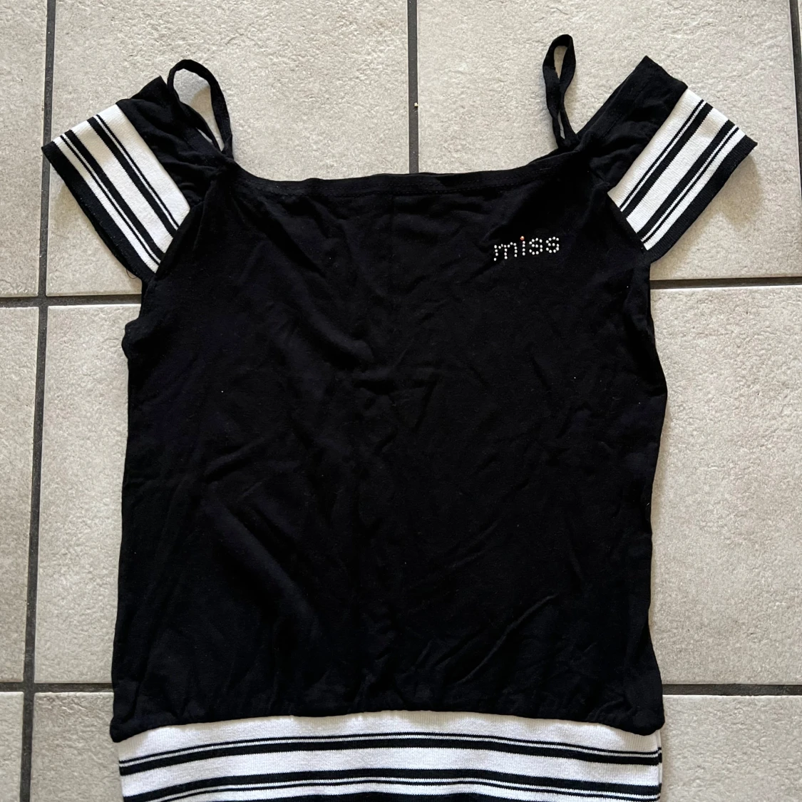 Svart topp med randiga detaljer