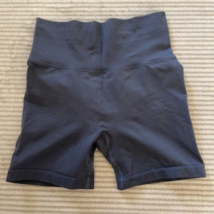  Träningsshorts   - Snygga blå/grå tränings shorts. De har en tight passform som framhäver figuren. 