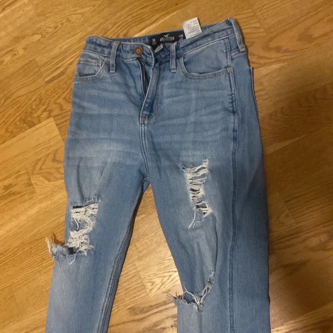 Blå jeans med slitningar