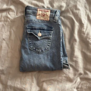  True Religion jeans becca - Blåa jeans från true religion i modellen ”becca”. De är köpta för ett par månader sedan men knappt använda. De har en fläck på höger ben som inte går bort (se bild 4) men den syns knappt, därav är priset billigare. Nypris: 1299kr Pris går att diskutera!!