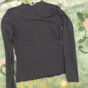 Svart ribbad tröja från ONLY - Säljer en svart ribbad tröja från ONLY i storlek S. Tröjan har långa ärmar och en enkel design med en rund halsringning. Perfekt för lager-på-lager eller som den är.