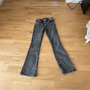 Grå bootcut jeans med knappar - Snygga grå jeans med bootcut-modell och midwest . 