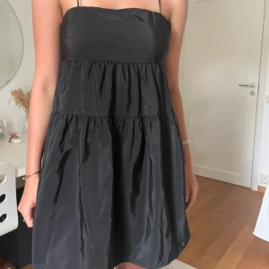 Svart  miniklänning med tunna axelband - Supersöt svart kort klänning med tunna axelband.  Materialet är glansigt. Dragkedja i sidan. Älskar den men använder inte längre🖤 från H&M, storlek 38