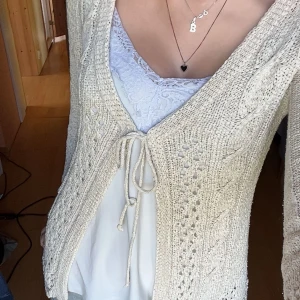 Beige stickad kofta med knyt - Trekvartsärm som är perfekt nu till sommaren, knappt använd :) Står ingen storlek men upplevs som S/M Längd: 62cm Axelbredd: 36cm Jag bär S/36 Hör av dig vid fler frågor!💕