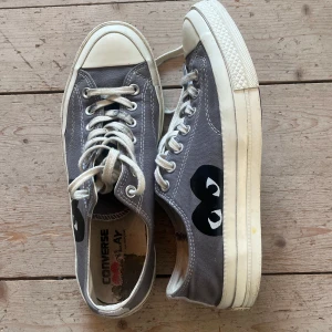 Grå Converse x CDG Play sneakers - Säljer min brorsas grå låga Converse x Comme des Garçons Play sneakersi storlek 43. De största slitaget är på innersulorna, annat syns på bilderna. Det tillkommer nya vita skosnören och nypriset är ca 1500kr