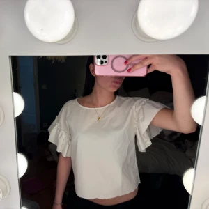 Vit blus med volangärmar - En söt vit blus med volang ärmar som jag klippt kortare därav kanten längst ner💕
