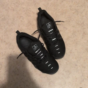 Nike Air Vapormax svarta sneakers den har skit små hålar man kan knappt märka - Svarta Nike Air Vapormax sneakers med reflekterande detaljer och snörning. Snygg sportig look med synlig luftdämpning i sulan och diskret Nike-logga. Ovandel i syntet och textil, bekväm passform och coola detaljer på hälen. Den har jätte små hållare i fram sidan av skorn