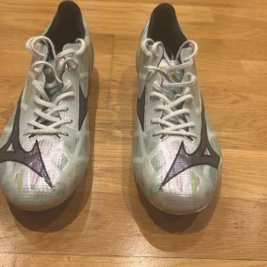 Mizuno vita fotbollsskor med mönster - Säljer ett par riktigt fina Mizuno dojor som är endast använda under en träning på ungefär 1,5 timmar.  Säljer pågrund av att dem är för små. Ny pris och köpta från Unisport för 3,699 kr. Bara att skriva om ni har några funderingar.