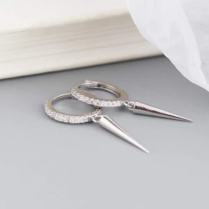 Silvriga örhängen  - Snygga silvriga örhängen i hoops-modell med glittrande strass på ringen och en spetsig spike-hänge. Lätta att bära och riktigt trendiga. S925 de är småa, finns en bild på hur småa de är där ja håller o hur de ser ut på tredje bilden när man har på sig. Den e jätte lätt att bära osv. INGEN RETUR!💕