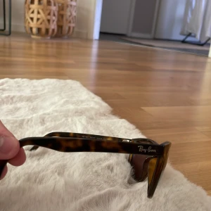 Bruna Ray-Ban solglasögon, fyrkantiga - Snygga Ray-Ban solglasögon med fyrkantig form och brunmelerat skal. Glasen är bruna och polariserade för extra komfort i solen. Klassisk logga på bågen och linsen. Perfekt accessoar för dig som vill ha en tidlös look. Väldigt lika boyfriend🙌