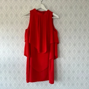 Röd ärmlös volangklänning - Röd klänning H&M perfekt för sommarens fester! Använd 2 gånger. Rökfritt hem! 