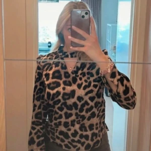 Leopardmönstrad topp - Superfin trendig blus i leopardmönster. Cool i halsen med unik urringning. 