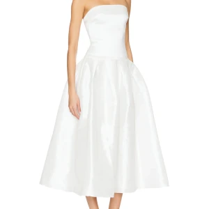 Vit axelbandslös långklänning - Superfin vit axelbandslös långklänning med utsvängd kjol och figurnära överdel. Användes en gång på min förlovningsfest. Super fin och elegant.